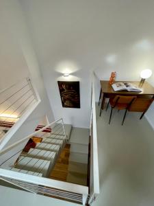 - un escalier dans une maison avec un bureau et une table dans l'établissement BORGO TICINO SUITE Attico di Lusso con Terrazzo e Parking Privato, à Pavia