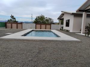 una piscina in un cortile accanto a una casa di Villas Brisas de Soley a La Cruz