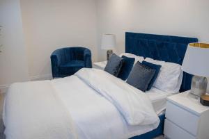 1 dormitorio con 1 cama grande y cabecero azul en Stylish Skylight Room in a Luxury House en Catford