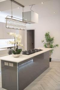 una cocina con una barra con flores. en Stylish Skylight Room in a Luxury House en Catford
