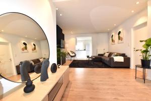 a living room with a mirror and a couch at Cosy apartment Airport Brussels with terrace in Zaventem