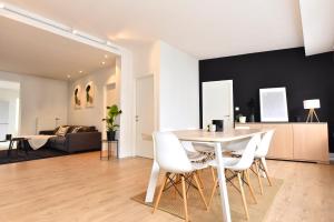 a dining room and living room with a table and chairs at Cosy apartment Airport Brussels with terrace in Zaventem