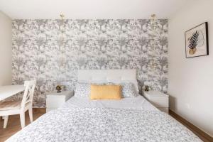 - une chambre avec un lit et un mur orné d'un papier peint tropical dans l'établissement El Toison 21 Parking Gratis-6 Pax Centro-Historico, à Bilbao