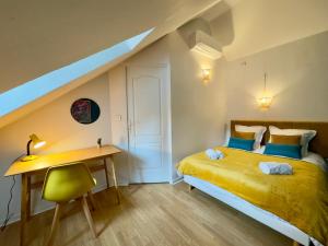 1 dormitorio con cama amarilla, escritorio y escalera en Maison 3ch - Cinéma - Game Room - Parking - Gare, en Amiens