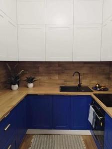 a kitchen with blue cabinets and a sink at Apartament blisko stacji kolejowej in Mińsk Mazowiecki