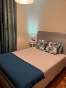 a bedroom with a bed with a blue blanket at Alojamento, Chelas Rural AL in Mirandela