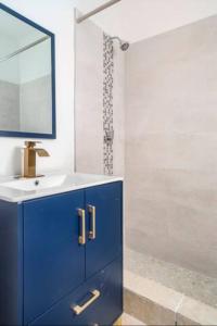 La salle de bains bleue est pourvue d'un lavabo et d'une douche. dans l'établissement Casa Lima in Villa Palmeras, à San Juan