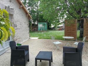 een patio met stoelen en een tafel en stoelen bij Gite Coté Jardin 2pers. in Saint-Gelais