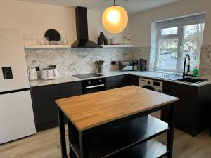a kitchen with black cabinets and a wooden table at Lux 1 Bed Flat - Free Parking in Oxford
