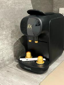 una macchinetta del caffè nera è seduta per terra di Petit 2 pièces Carré d'Or a Nizza