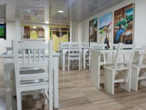 a dining room with white tables and white chairs at Casa Salento in Salento