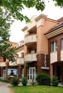 a building with a man standing outside of it at Grace Apartman in Hajdúszoboszló