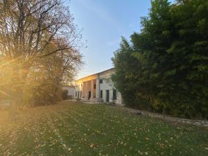 una casa con un patio con hojas en el césped en Agriturismo Barchessa, en Este