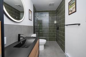 Un baño con lavabo, inodoro y espejo. en The Cozy Country Den, en Quebec 11 fotos más