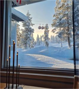 uma janela com vista para um pátio coberto de neve em Vuosselin Helmi C11 em Kuusamo