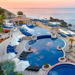 a resort with a pool and chairs and the ocean at VISTA ENCANTADA AT HACIENDA ENCANTADA & SPA RESORT- apartment in Cabo San Lucas