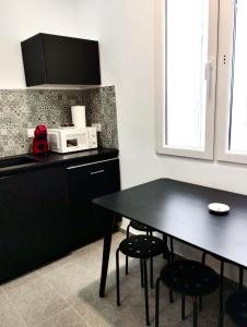 a kitchen with a black table and a microwave at Soho Boho Apartments - with sunny rooftop terrace and fiber optic internet in Alicante