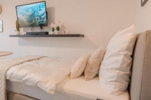 un sofá blanco con almohadas en una habitación en Zentral nah MHH Terrasse Komfort - Haustiere willkommen en Hannover