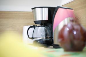 a coffee maker sitting on a table with a cup at Appartement en rez-de-chaussée avec jardin in Saint-Genis-Laval