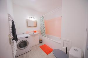 a bathroom with a washing machine and a sink at Appartement en rez-de-chaussée avec jardin in Saint-Genis-Laval +2 photos