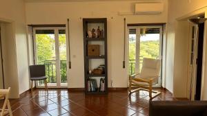 ein Wohnzimmer mit 2 Stühlen und 2 Fenstern in der Unterkunft Alto do Sobreiro in Escalos de Cima