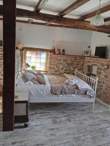 a bedroom with a bed and a brick wall at La Casina de Asturias in Mieres