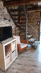 een woonkamer met een bank en een tv bij La Casina de Asturias in Mieres