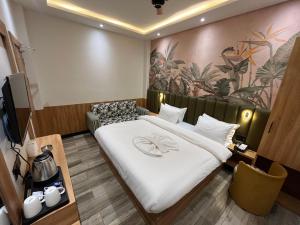 ein Hotelzimmer mit einem großen Bett in einem Zimmer in der Unterkunft Ashoka Hotel in Gorakhpur