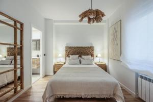 um quarto com uma cama grande e 2 candeeiros em Jardines de Sabatini em Madri