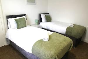 two beds in a hotel room with two ottomans at *The Marshall*ContractorsStays*MonthyStays* in Leicester