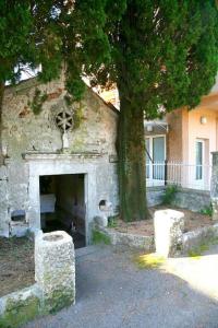 a stone building with a fireplace in front of a tree at Sea Star Danica apartments in Tivat