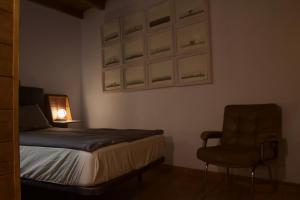 een slaapkamer met een bed, een stoel en een lamp bij Tiny House: The Housje in Puerto de la Cruz +11 foto's