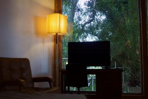 een woonkamer met een televisie en een raam bij Tiny House: The Housje in Puerto de la Cruz