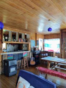 a living room with a wooden ceiling and a table at Hostal Casa Damasco in Ancud