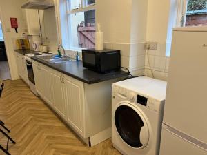 a kitchen with a washing machine and a microwave at *The Marshall*ContractorsStays*MonthyStays* in Leicester