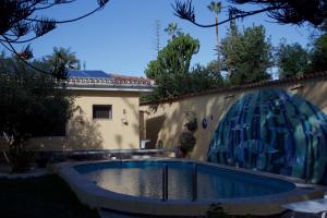een zwembad in de achtertuin van een huis met een schilderij aan de muur bij Tiny House: The Housje in Puerto de la Cruz