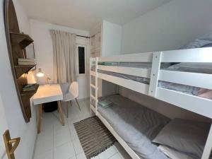 a room with two bunk beds and a desk at Precioso Apartamento en Es Grau in Es Grau
