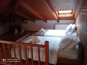 a bedroom with two beds and a wooden ceiling at Agora Mansion in Arachova