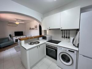 a kitchen with a sink and a washing machine at Precioso Apartamento en Es Grau in Es Grau