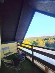 a table and a chair on a balcony with a view at Holiday home Sunce i Zora in Jalžabet