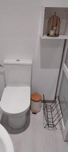 uma casa de banho branca com um WC e uma prateleira em Studio indépendant em Laval