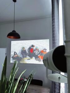 a painting of a group of people on a screen at Inner City Design Loft in Innsbruck