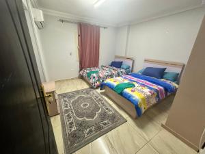 מיטה או מיטות בחדר ב-Misr Al Jadedah Rooms