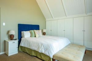 Schlafzimmer mit einem großen Bett mit blauem Kopfteil in der Unterkunft Midlands Cottage with Views in Henburg Park