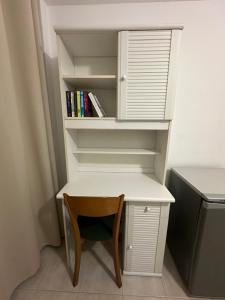 a desk with a chair and a book shelf at Casa Di Gio in Portimão