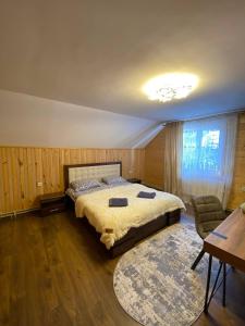 um quarto com uma cama, uma mesa e um tapete em На Закуті em Mykulychyn