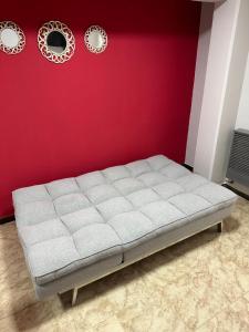 a bed in a room with a red wall at Paseo Costero Apart in Comodoro Rivadavia