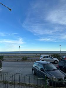 two cars parked in a parking lot near the ocean at Paseo Costero Apart in Comodoro Rivadavia