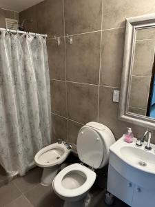 a bathroom with a toilet and a sink at Paseo Costero Apart in Comodoro Rivadavia