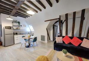a living room with a black couch and a table at Cœur de Ville - T3 - 6 personnes - Arrivée Autonome in Tours